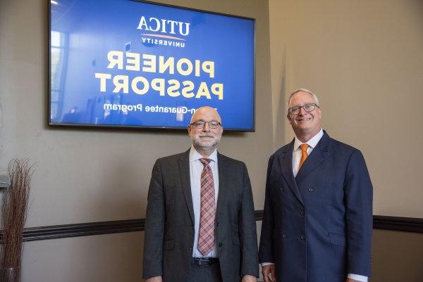 President 托德Pfannestiel and VP of Enrollment Management Eric Sykes stand in front of monitors announcing 先锋的护照.